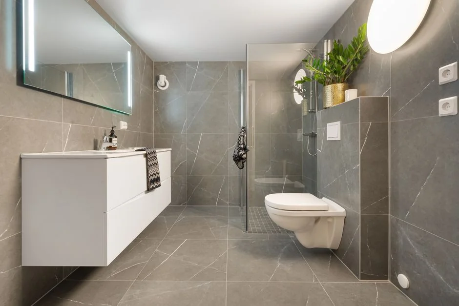 who-we-are Stylish interior with moving boxes labeled Kitchen and Office on a wooden table surrounded by houseplants.